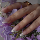 White French nails with modeling hands holding flowers by Inglass Nails. Reusable nail extensions. 