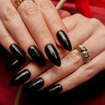 Black solid color Reusable nail extensions in long almond length. 