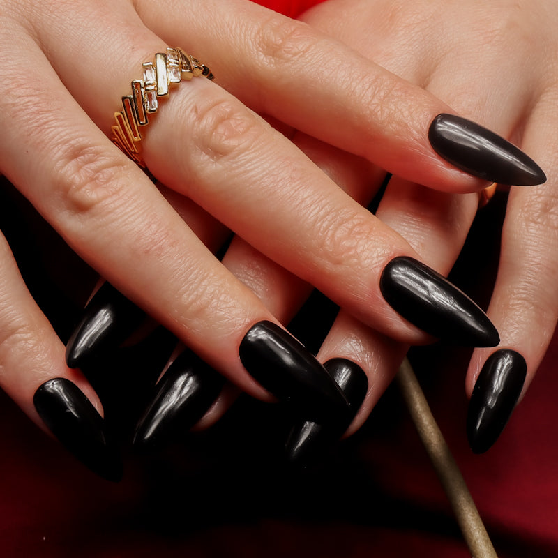 Black solid color Reusable nail extensions in long almond length. 