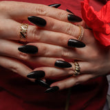 Black solid color Reusable nail extensions in long almond length. 