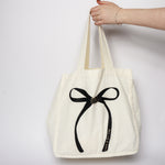 Canvas tote cotton with black and gold bow. 