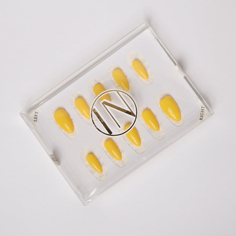 Yellow solid color Reusable nail extensions in long almond length. 