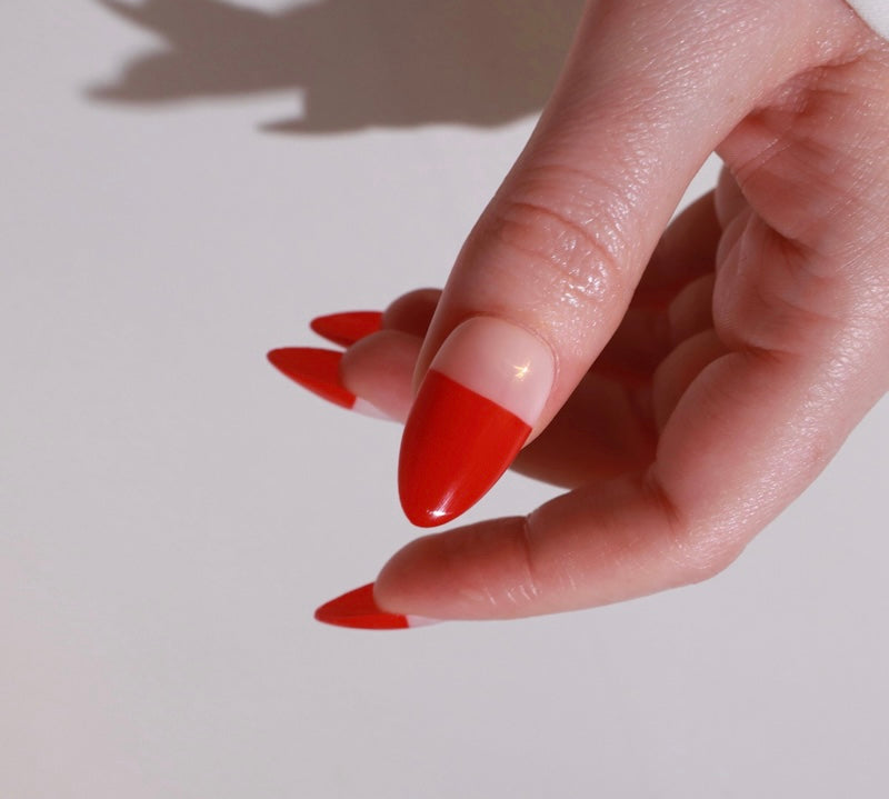 Reusable nail extensions red abstract French in long almond length.