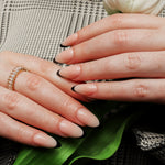 Reusable nail extensions in long almond length French nails. 