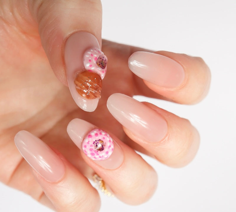 Reusable nail extensions doughnuts 3D art in long almond length.