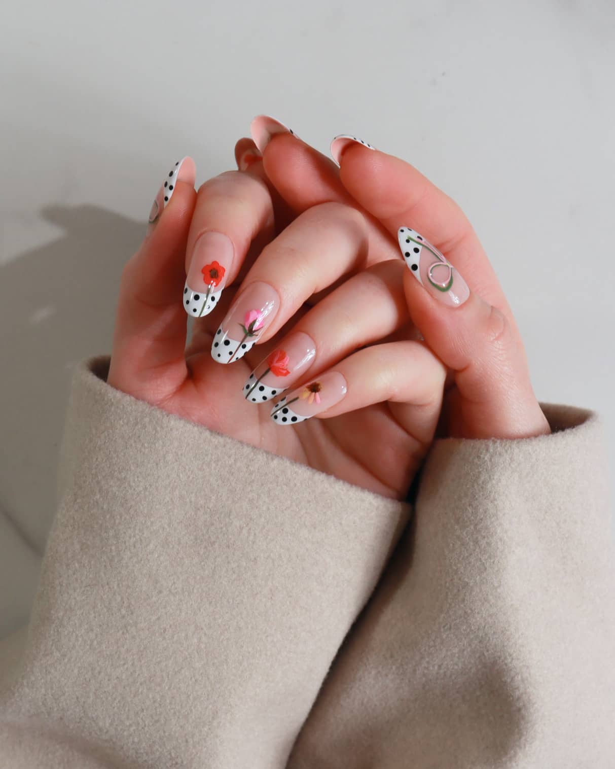 Close-up of hands with stylish nail art on a neutral background