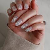 Hand with glittery gel polish on a neutral background
