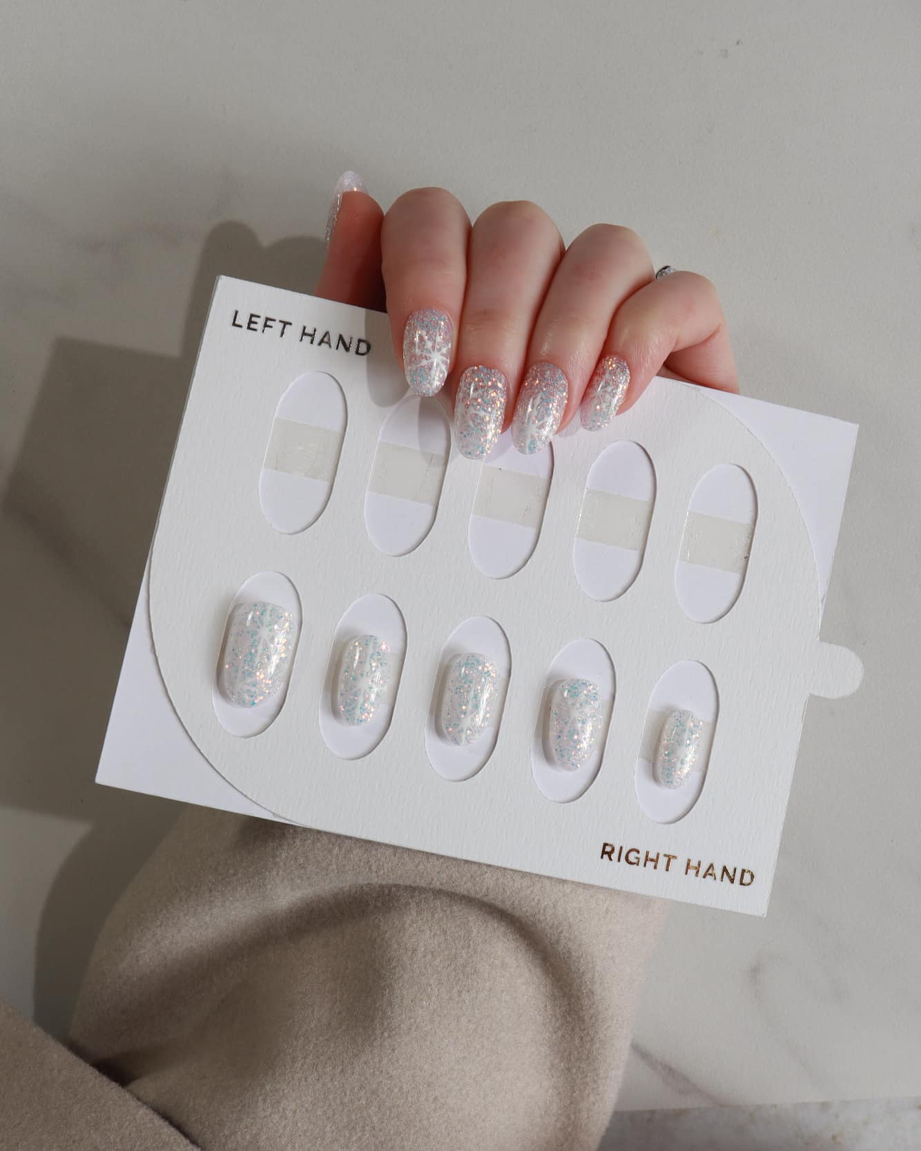 hand model displaying glittery nail designs.