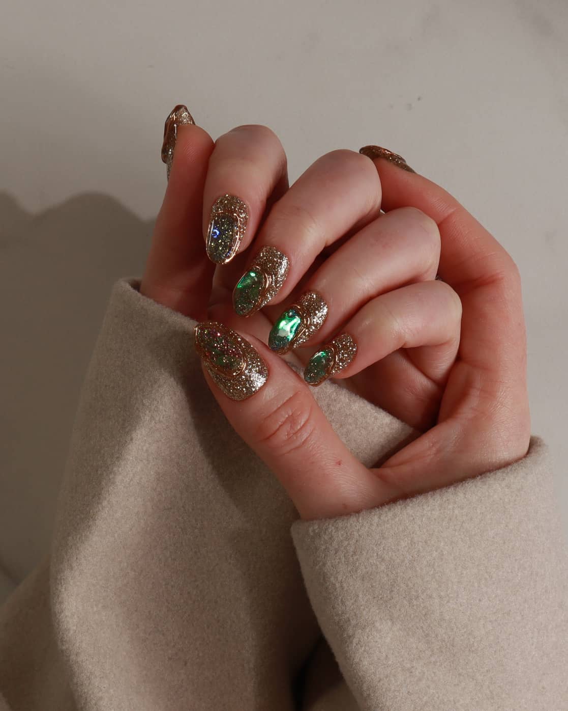 Hand with glittery polish holding a beige fabric