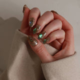 Hand with glittery polish holding a beige fabric