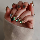 Close-up of a hand with ornate nail art wearing a beige sweater.