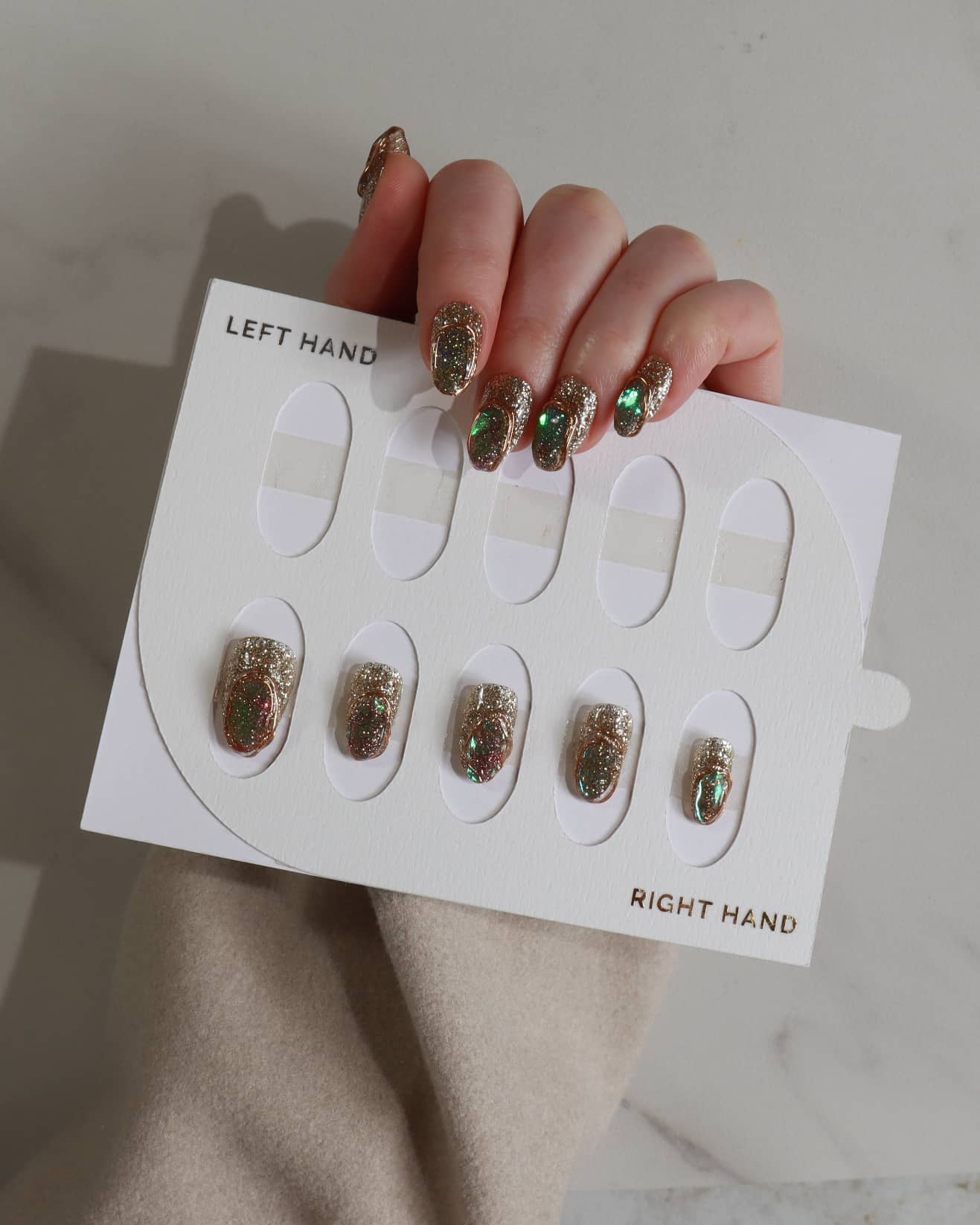 Nail art display with glittery nail designs on a neutral background