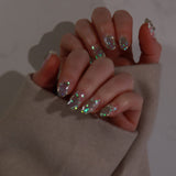 Close-up of a hand with glittery nail polish on a neutral background