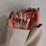Close-up of hands with decorative nail art against a neutral background