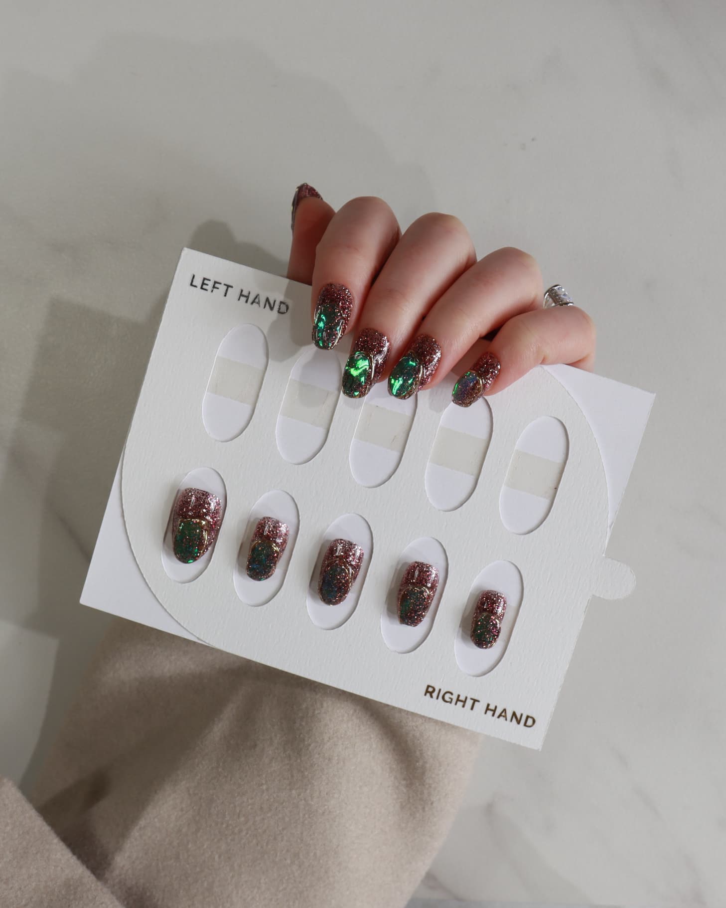 Nail art display with glittery nail designs on a neutral background