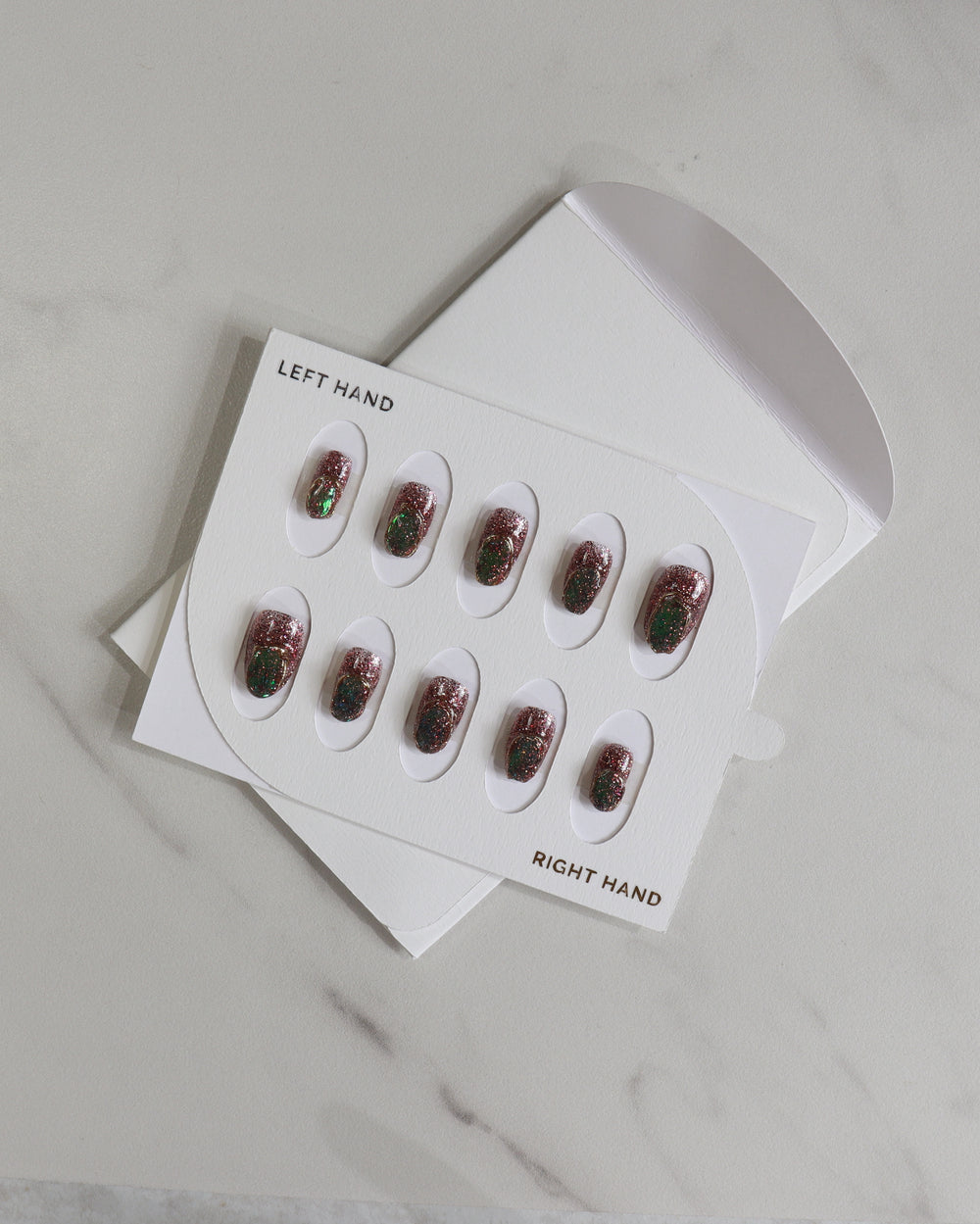 Set of nail extensions in a white box on a light gray background