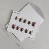 Nail art stickers in a white box on a light gray surface