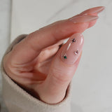 Close-up of a hand with decorative nails on a plain background