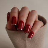 Hand with red nail polish on a neutral background