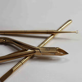 Gold-colored nail tools on a white background