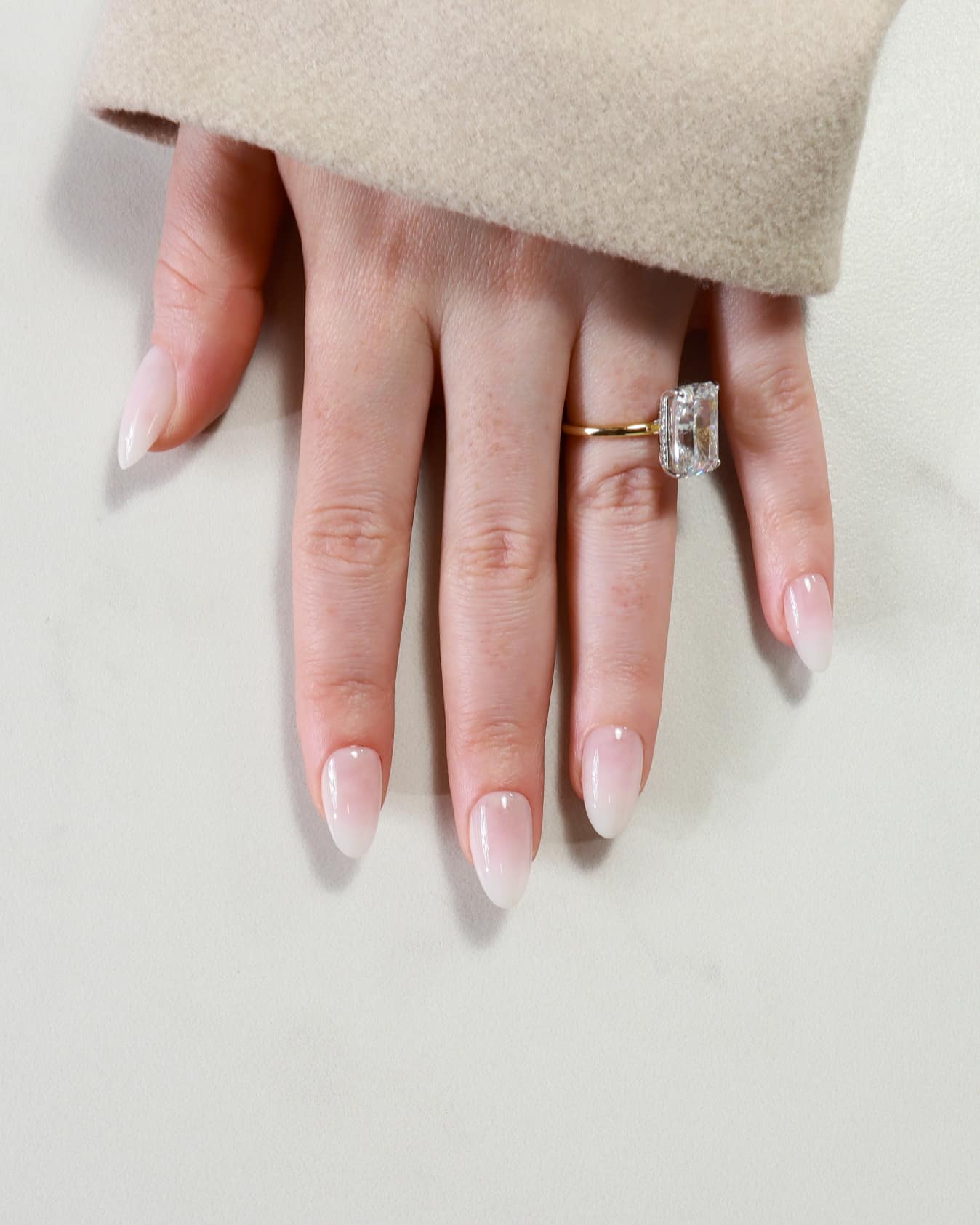 Close-up of a hand wearing two rings on a light background