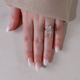 Hand wearing a diamond ring on a neutral background