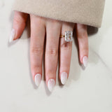 Hand wearing a diamond ring on a light background