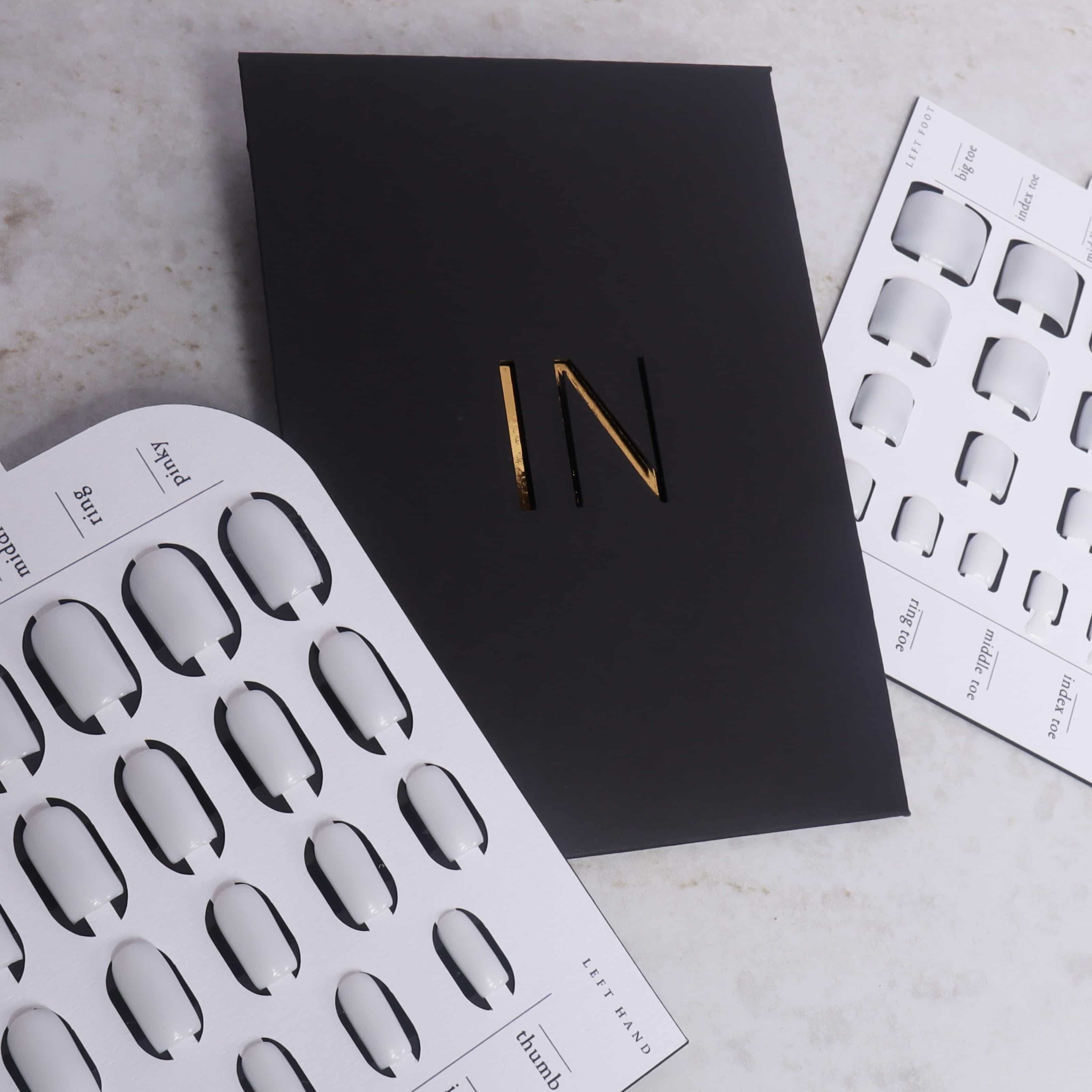 Black card with 'IN' on it, surrounded by white templates on a light gray surface