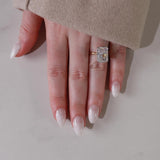 Hand wearing a diamond ring on a neutral background with shade in05