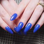 Blue solid color Reusable nail extensions in long almond length. 