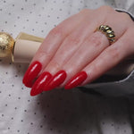 Red solid color Reusable nail extensions in long almond length. 