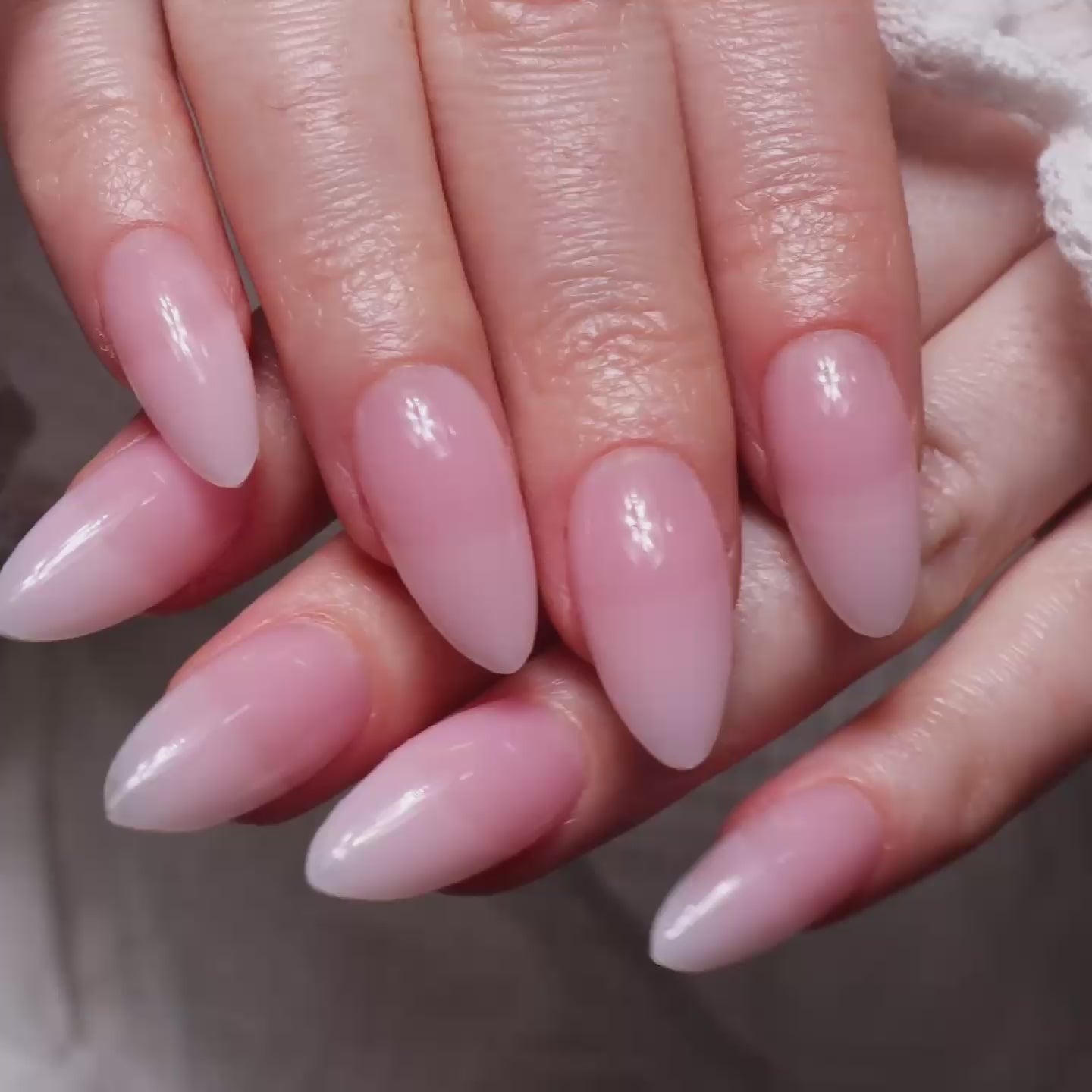 Reusable nail extensions in long almond length French nails. 