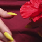 Yellow solid color Reusable nail extensions in long almond length. 