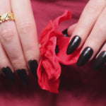 Black solid color Reusable nail extensions in long almond length. 