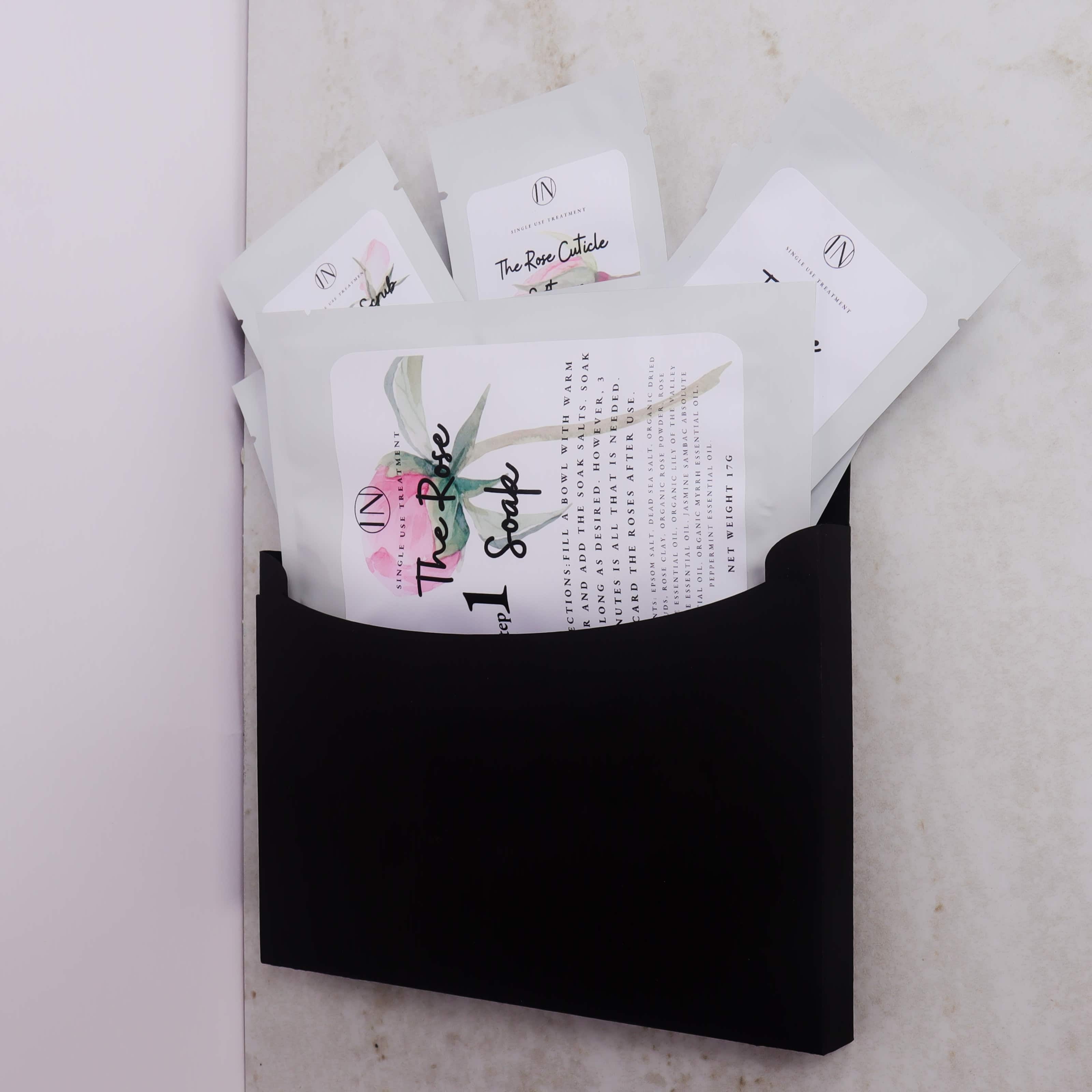 Black pouch with manicure and pedicure spa kit on a light marble background